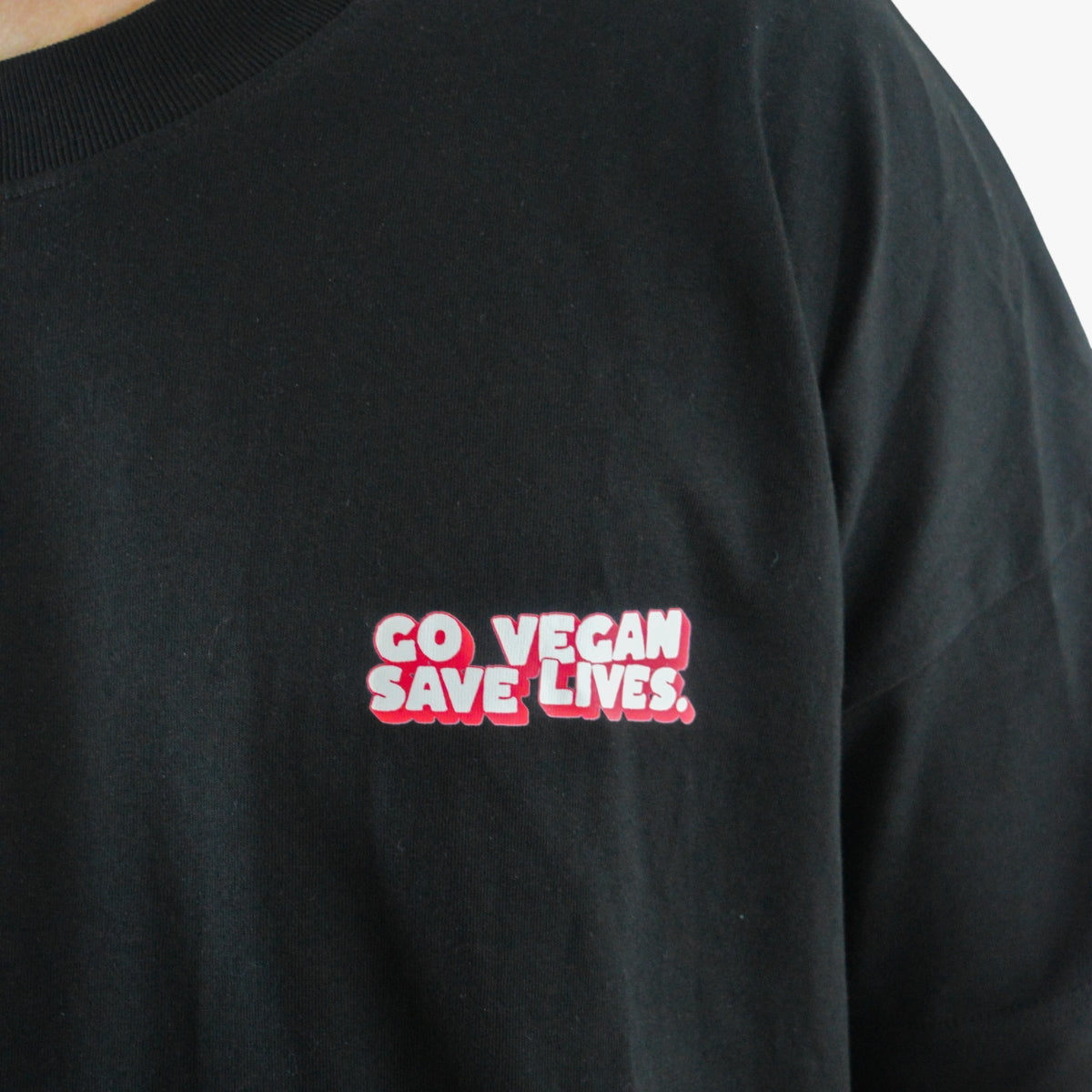 'GO VEGAN SAVE LIVES' Organic Oversize Shirt in der Farbe Black als Front Detailaufnahme getragen von einem männlichen Model