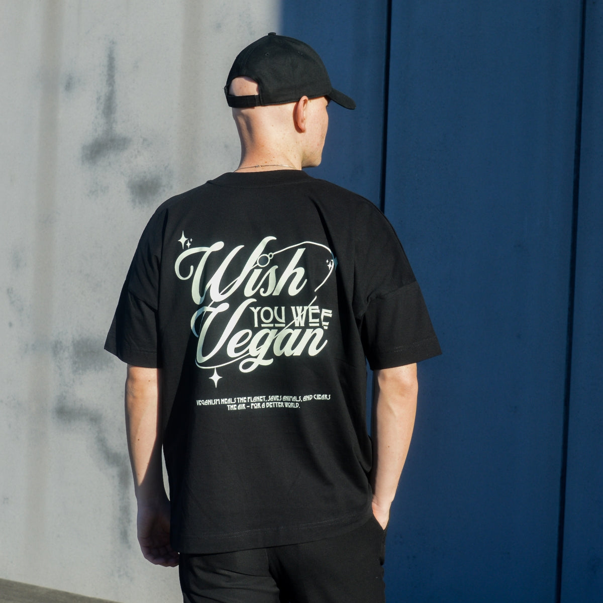 'WISH YOU WERE VEGAN Stars' Organic Oversize Shirt in der Farbe Black als Back Pose Nahaufnahme getragen von einem männlichen Model