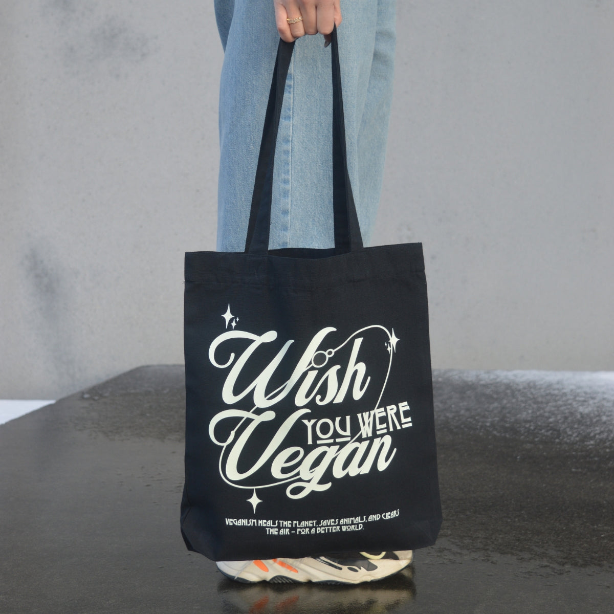 'WISH YOU WERE VEGAN Stars' Organic Tote-Bag in der Farbe Black als Detailaufnahme gehalten von einem weiblichen Model